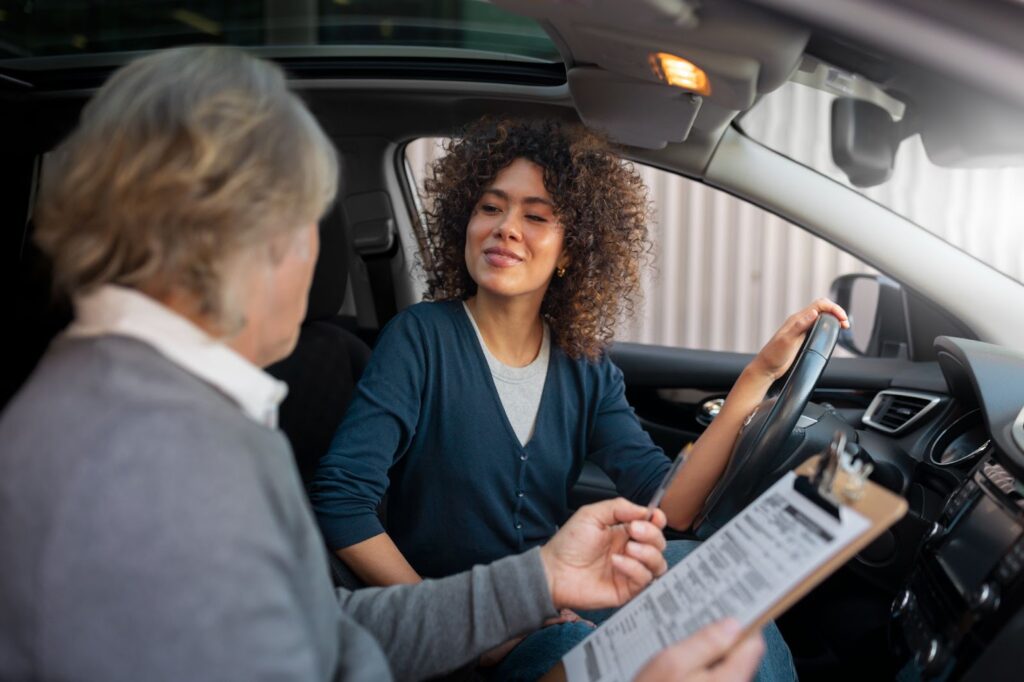 Woman smiling while talking to an elderly man in a car.