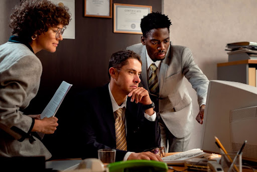 Three professionals collaborating in an office setting.