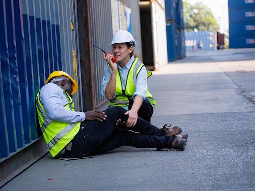 Two construction workers helping each other on a job site.