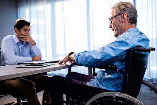 Two men in a serious discussion, one in a wheelchair.