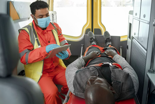Paramedic assisting patient inside an ambulance.