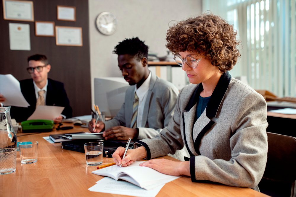 Professionals engaged in a focused business meeting, taking notes and discussing ideas.