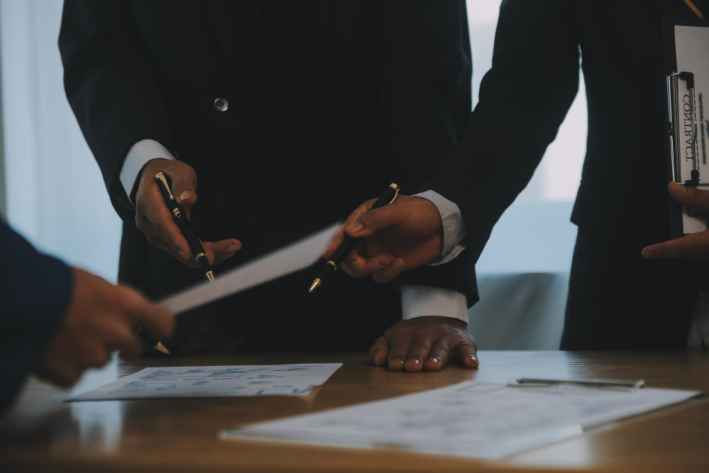 Two people in suits reviewing documents together.